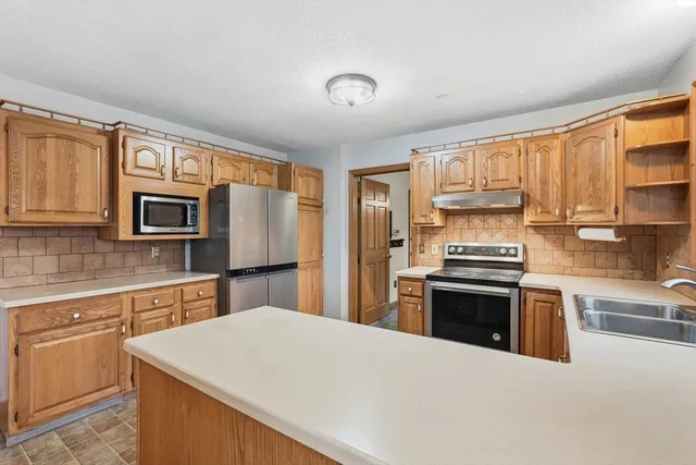 a kitchen with stainless steel appliances a stove sink microwave and refrigerator