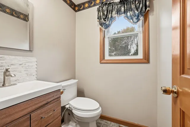 a bathroom with a toilet sink and mirror