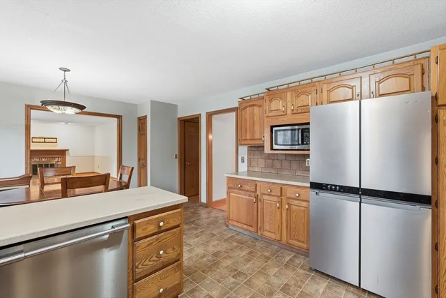 a kitchen with stainless steel appliances granite countertop a refrigerator and a sink