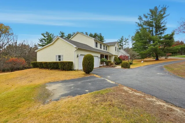 a view of a house with a yard and covered with snow in the background