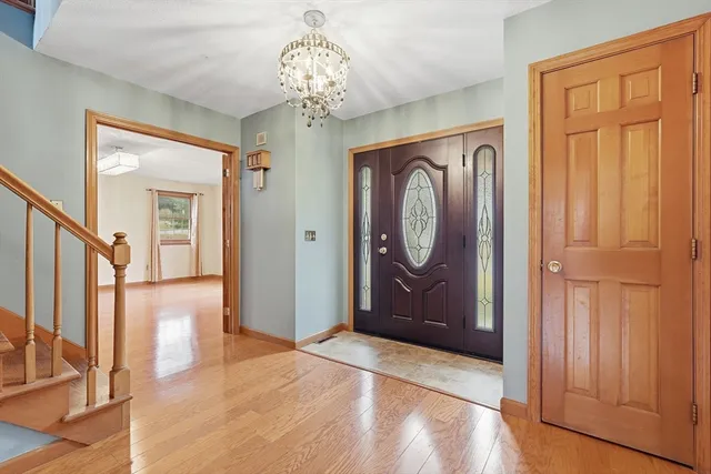 a view of a hallway with wooden floor and chandelier