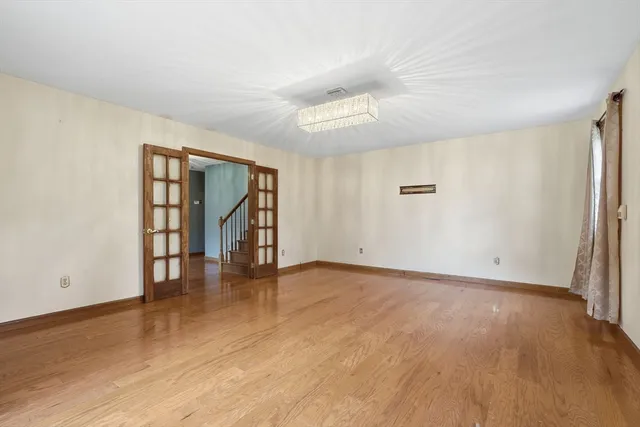 an empty room with wooden floor and cabinet