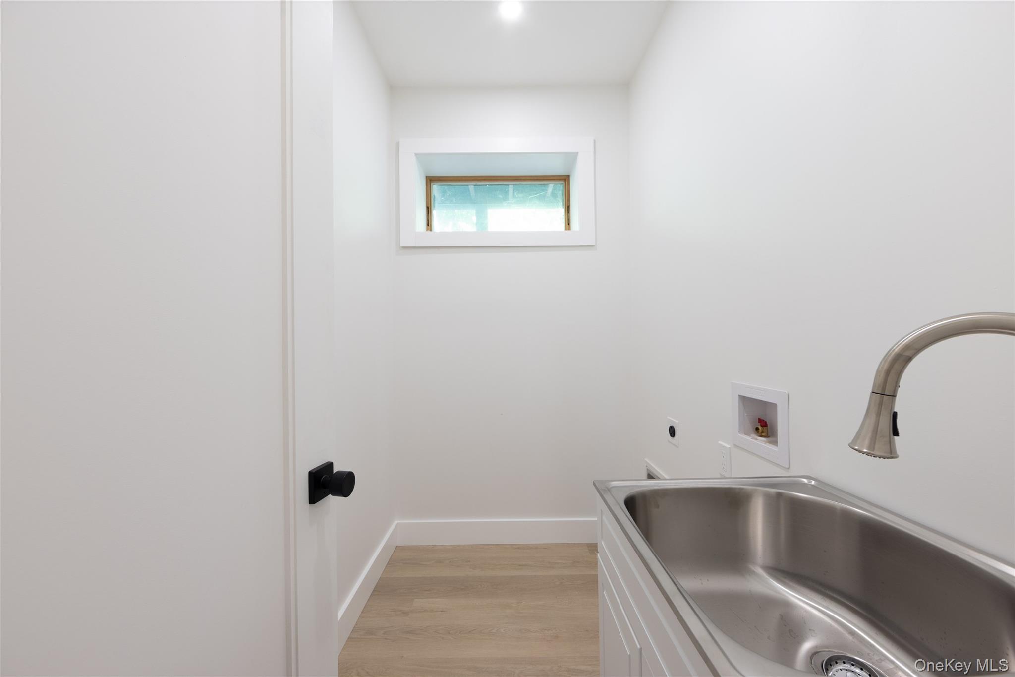 91 Lenni Lenape Road Narrowsburg, NY 12764 - Photo 12 of 25 Utility sink with brushed nickel faucet, light wood-finish flooring, white cabinetry, and recessed lighting, washer and dryer hook up