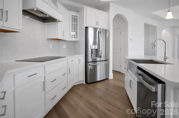 a kitchen with white cabinets and stainless steel appliances