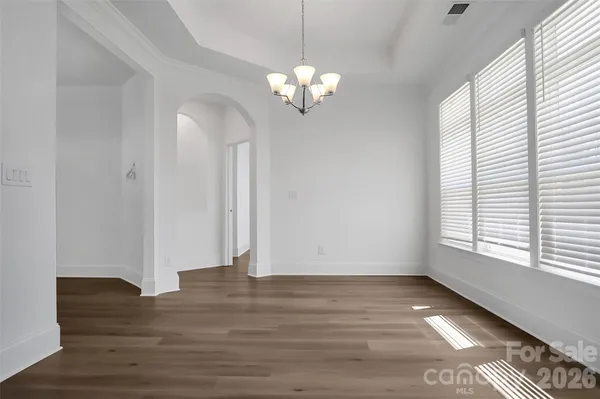 a view of a room with wooden floor and chandelier
