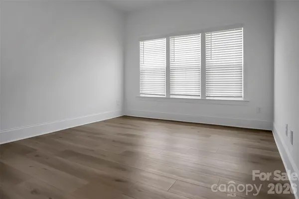 an empty room with wooden floor and window