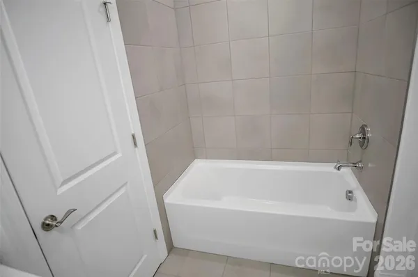 a white bath tub sitting next to a white sink and vanity