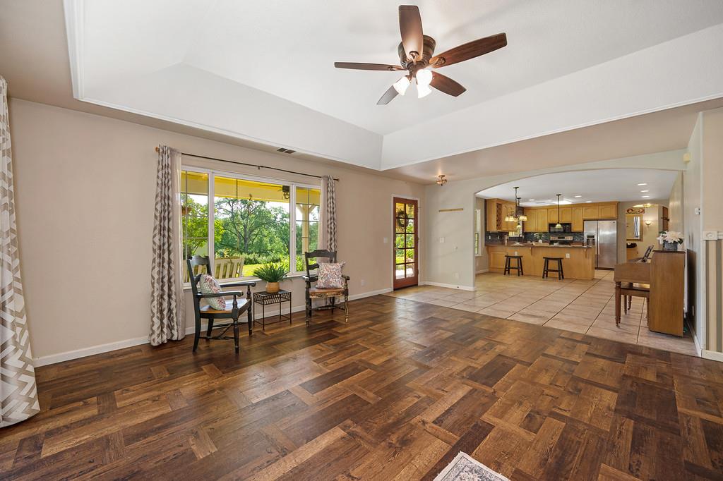 6181 Lambert Lane El Dorado, CA 95623 - Photo 18 of 68 living room with a ceiling fan, arched walkways, dark wood finished floors, and a raised ceiling