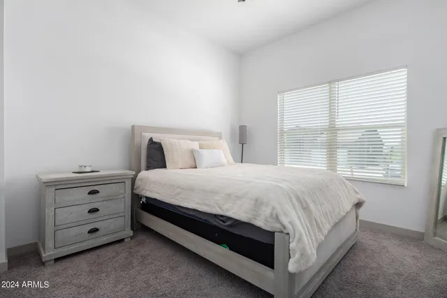 a bed sitting in a bedroom next to a window