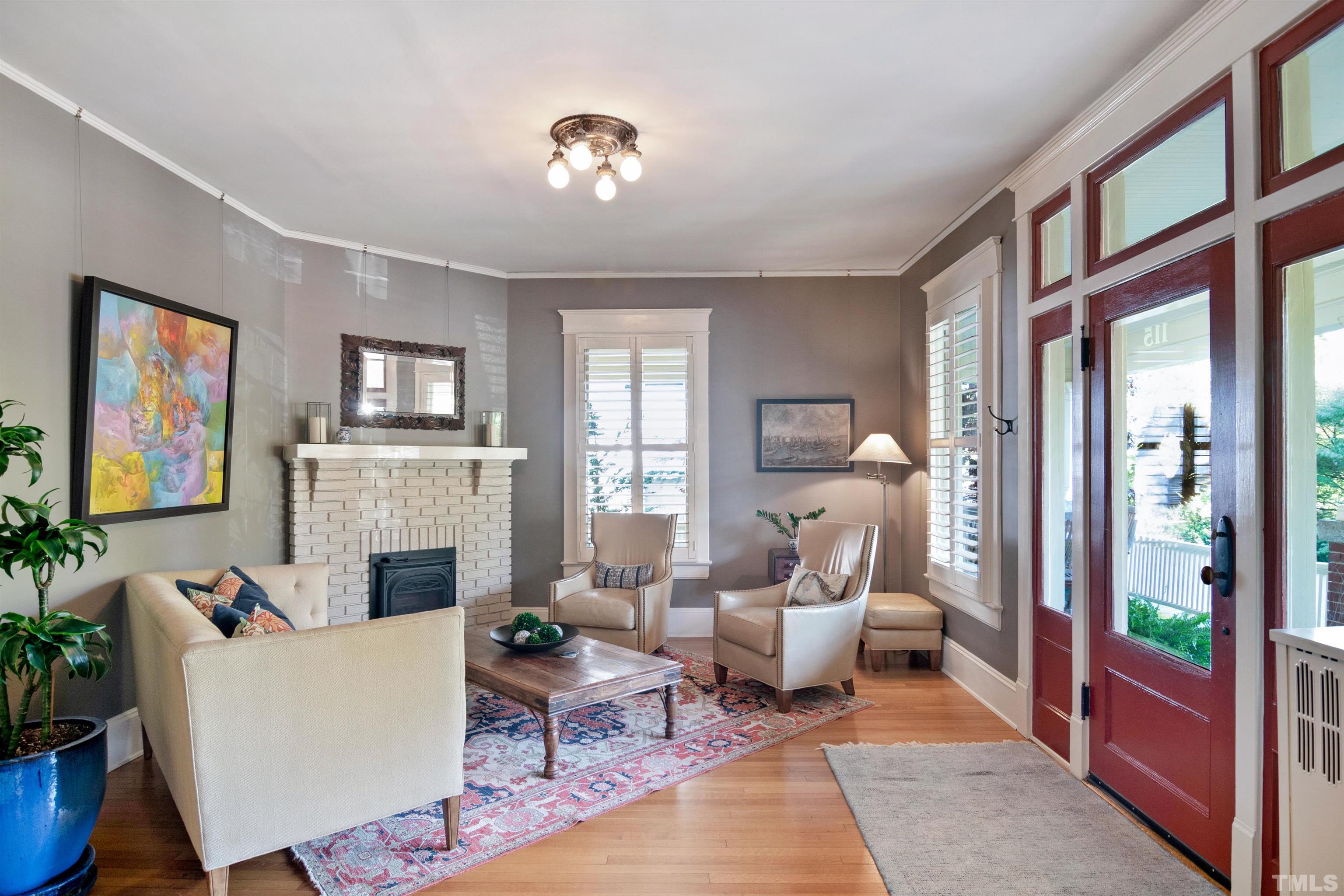 115 Watts Street Durham, NC 27701 - Photo 5 of 30 a living room with furniture a fireplace and a flat screen tv