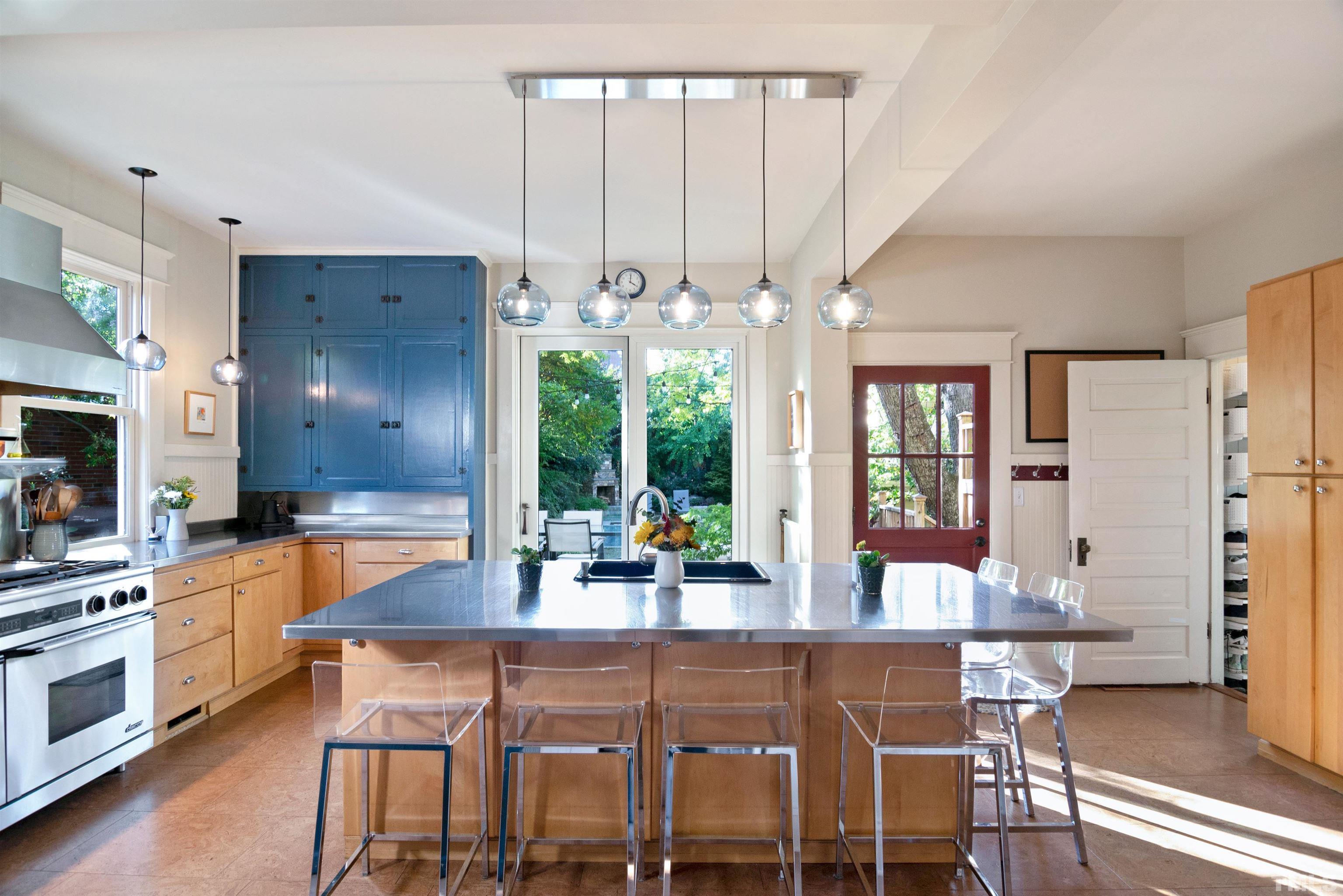 115 Watts Street Durham, NC 27701 - Photo 9 of 30 a kitchen with stainless steel appliances a dining table chairs and chandelier