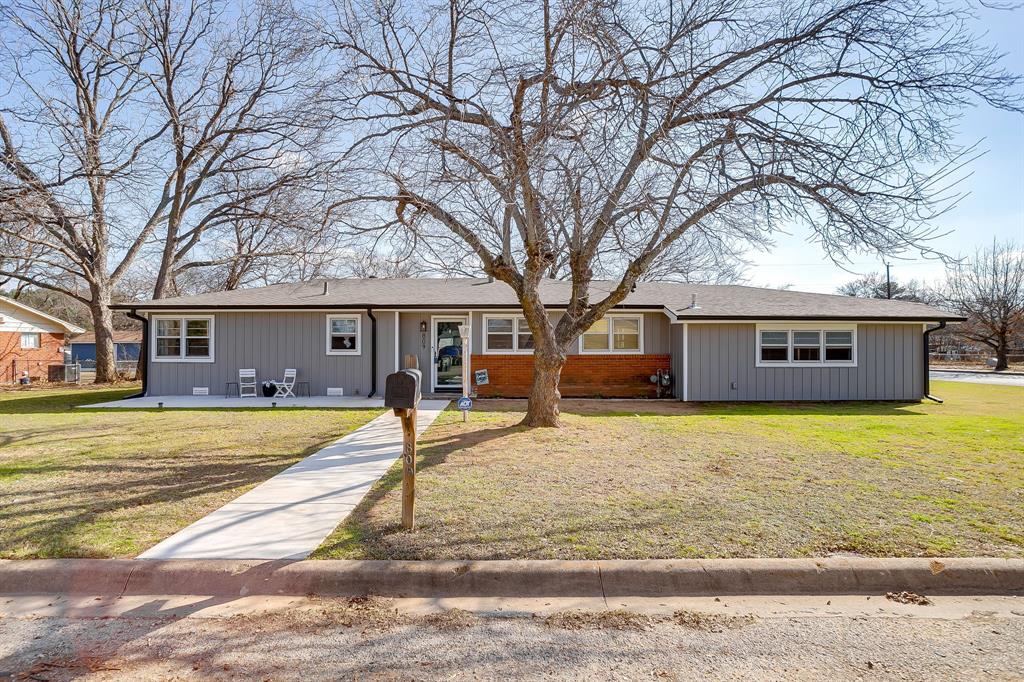 a front view of a house with a yard and trees