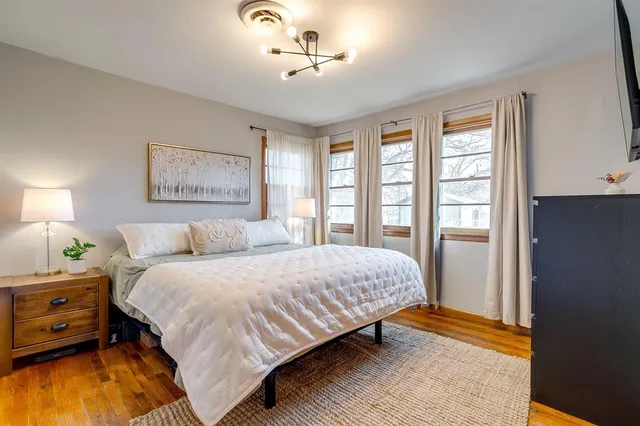 a bedroom with a bed dresser and a window