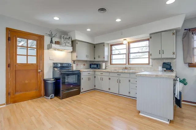 a kitchen with a refrigerator stove top oven and sink