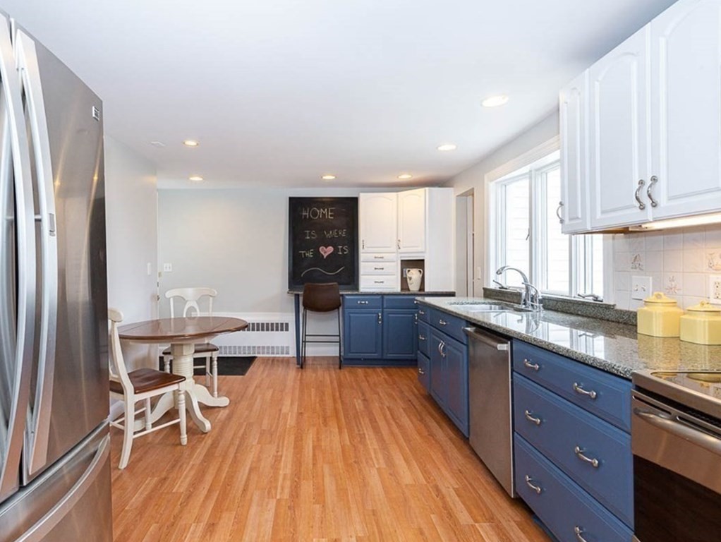 26 Bow Road Newton, MA 02459 - Photo 20 of 37 a kitchen with stainless steel appliances granite countertop a refrigerator a sink dishwasher a stove and white countertops with wooden floor