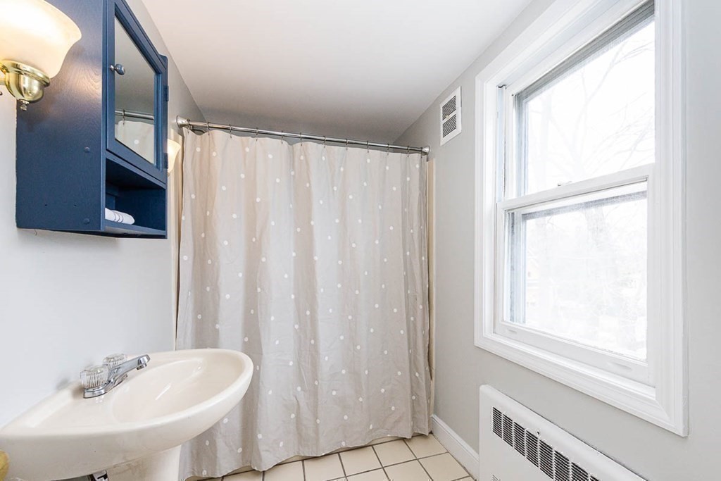 26 Bow Road Newton, MA 02459 - Photo 29 of 37 a bathroom with a sink a mirror and a shower