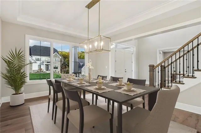 a dining room with wooden floor a chandelier a wooden table and chairs