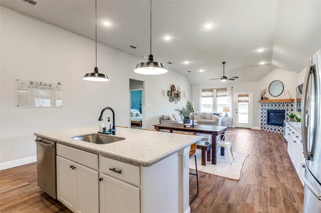 a kitchen with sink stove and wooden floor