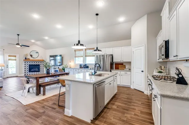a kitchen with stainless steel appliances kitchen island granite countertop a sink and a stove