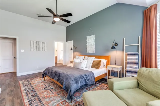 a bedroom with a bed and a dresser with wooden floor