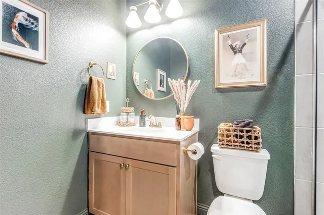 a bathroom with a toilet a sink and mirror