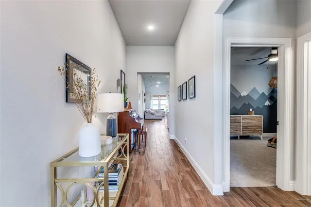 a view of a hallway with furniture and wooden floor
