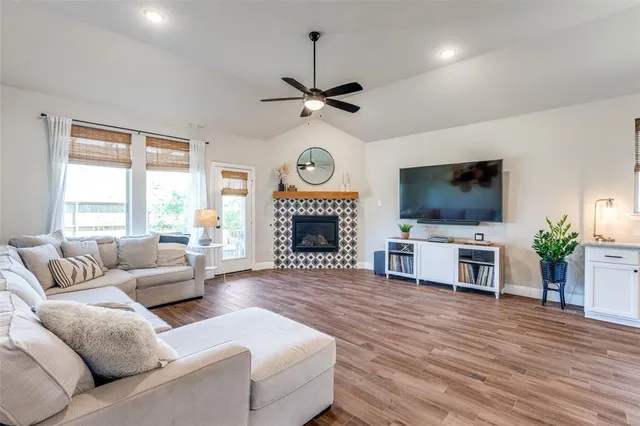 a living room with furniture a fireplace and a flat screen tv