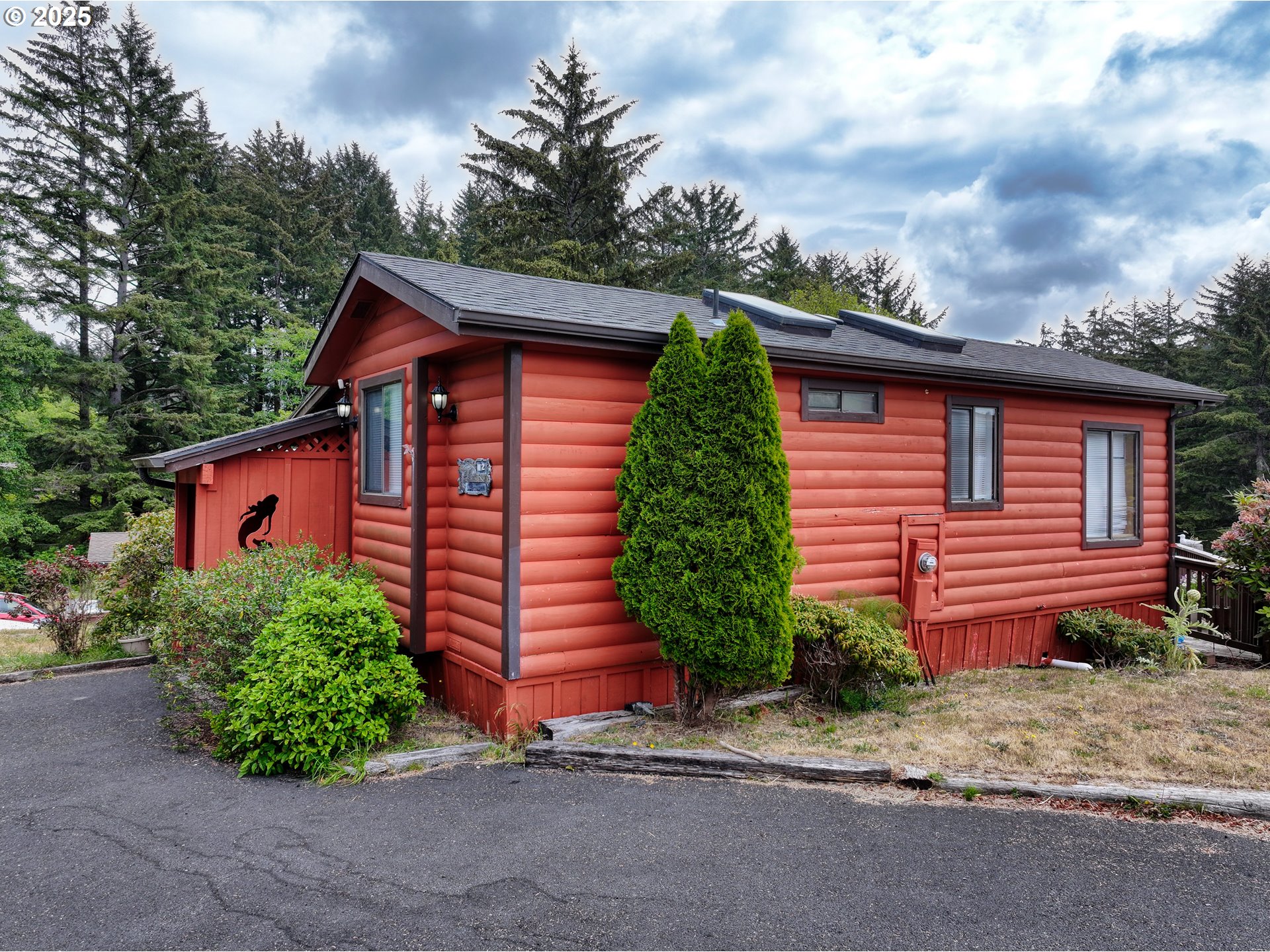 19921 Whaleshead Road, Unit M2 Brookings, OR 97415 - Photo 4 of 29 a view of a house with a yard plants and large tree