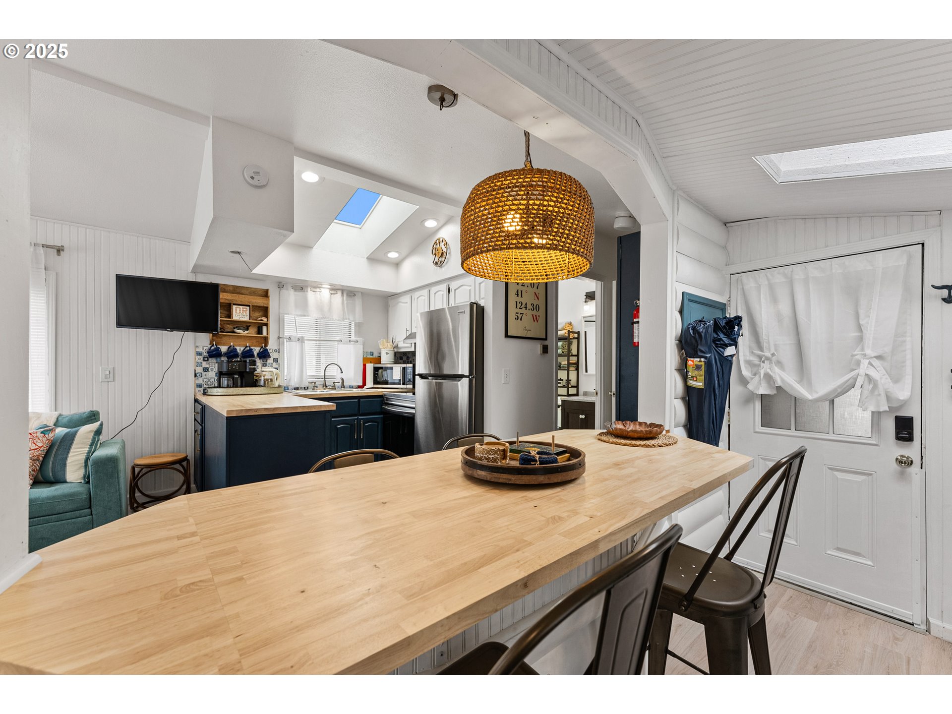 19921 Whaleshead Road, Unit M2 Brookings, OR 97415 - Photo 10 of 29 a kitchen with stainless steel appliances kitchen island granite countertop a table chairs in it and wooden floors