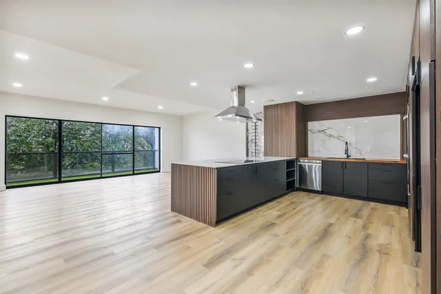 a large kitchen with stainless steel appliances wooden cabinets and a large window