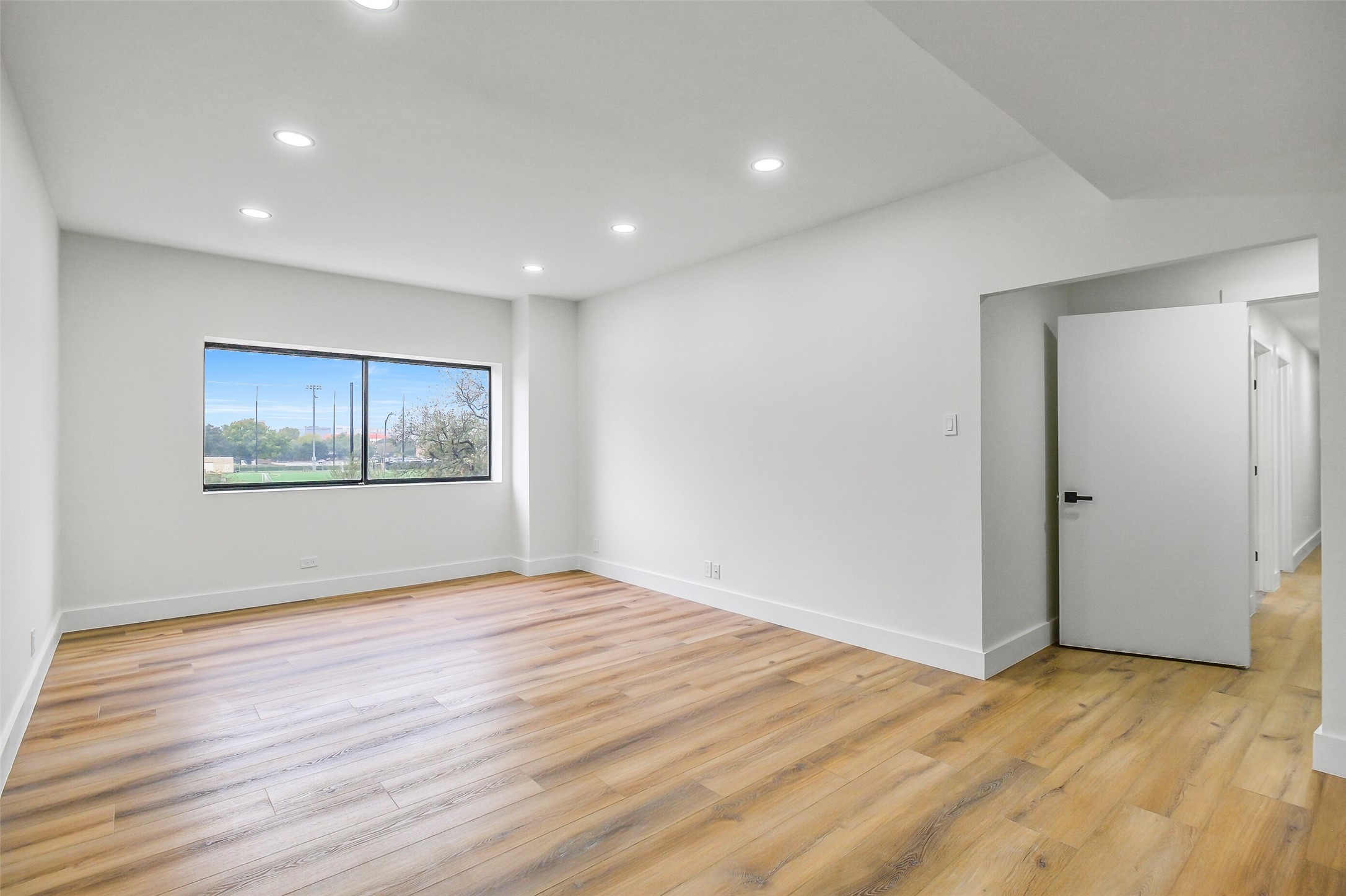 2929 Buffalo Speedway, Unit A204 Houston, TX 77098 - Photo 17 of 27 a view of an empty room with wooden floor and a window