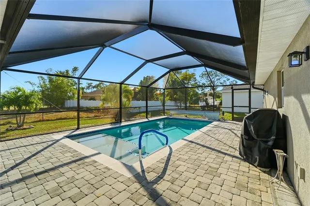 a view of a backyard with table and chairs under an umbrella