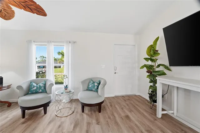 a living room with granite countertop furniture a flat screen tv and kitchen area