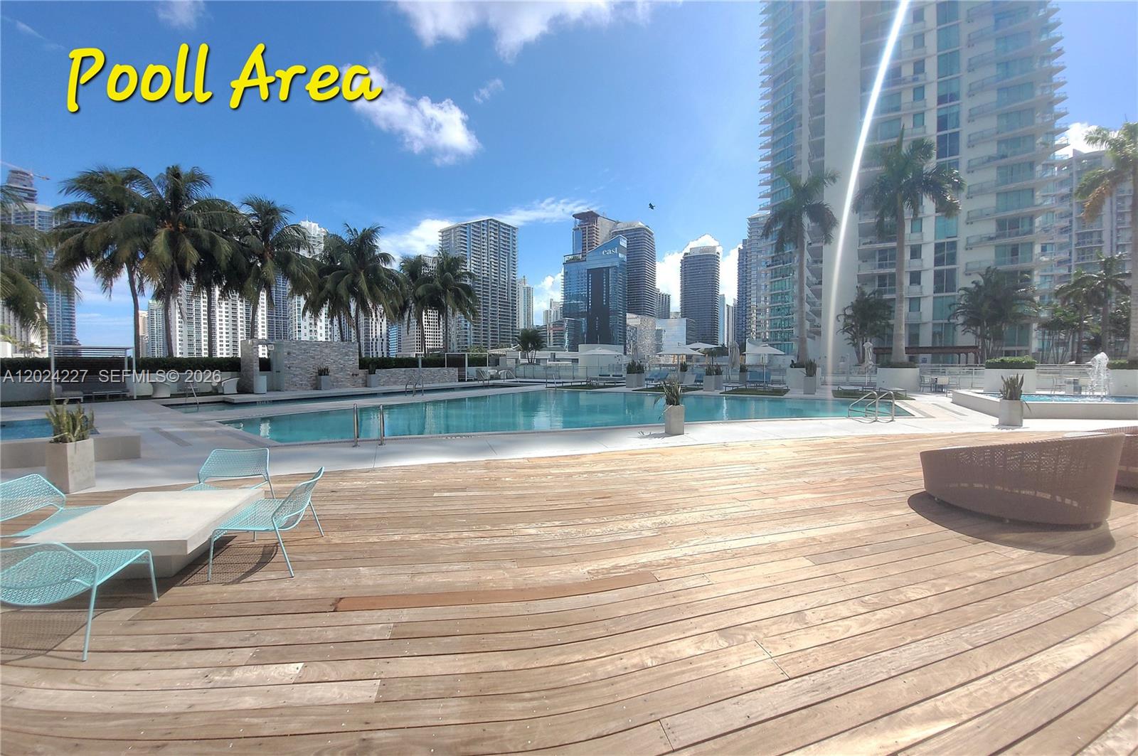 90 Southwest 3rd Street, Unit 2208 Miami, FL 33130 - Photo 26 of 56 a view of a swimming pool with a bench and palm trees