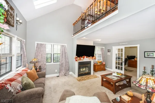 a living room with furniture a flat screen tv and a large window