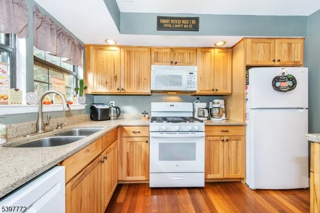 a kitchen with stainless steel appliances granite countertop a sink a stove and a refrigerator