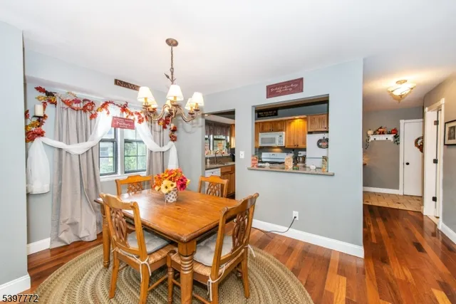 a dining room with furniture a chandelier and wooden floor