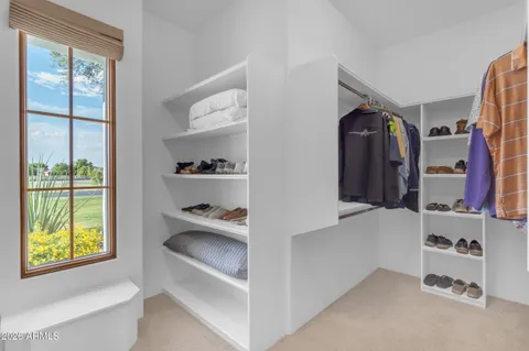 a view of walk in closet with clothes and shoes