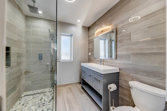 a bathroom with a double vanity sink toilet mirror and shower