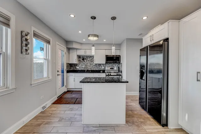 a kitchen with stainless steel appliances granite countertop a refrigerator and a sink