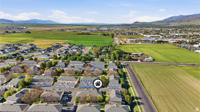 99 Penhurst Place Logan, UT 84341 - Photo 29 of 34 Residential community featuring multiple townhome structures and single-family homes, surrounded by expansive green fields and distant mountains