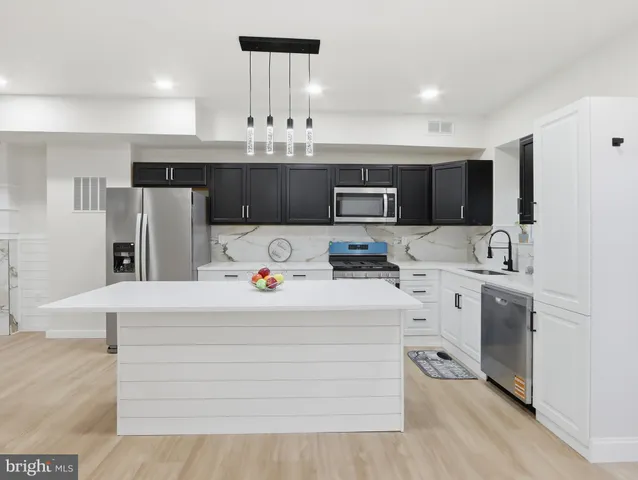 a kitchen with appliances a sink and cabinets