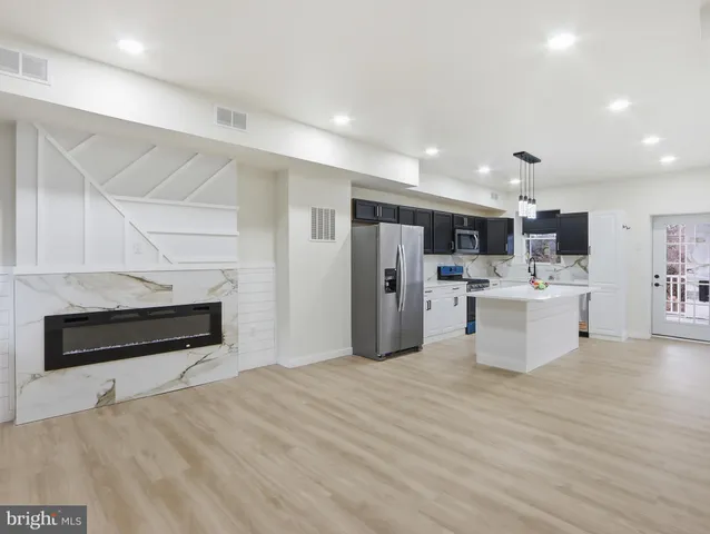 a kitchen with stainless steel appliances kitchen island a refrigerator and a stove top oven