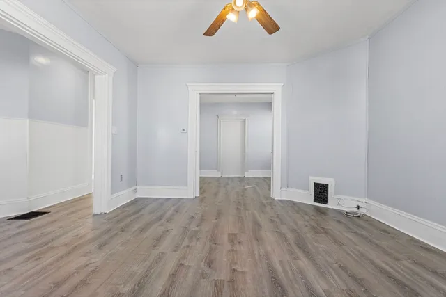 a view of empty room with wooden floor