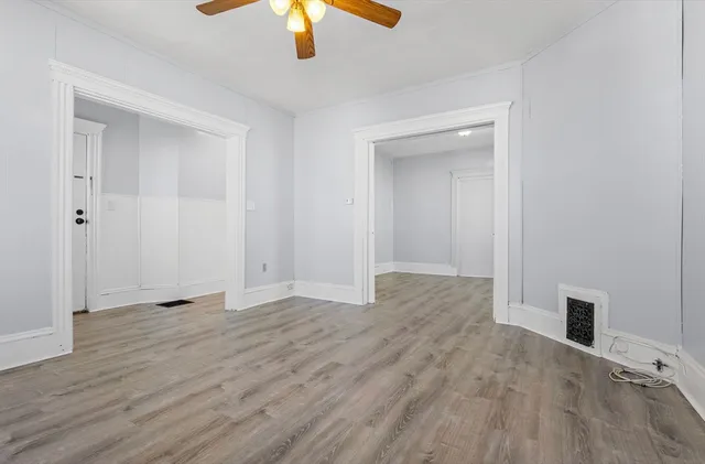 a view of an empty room with a chandelier fan
