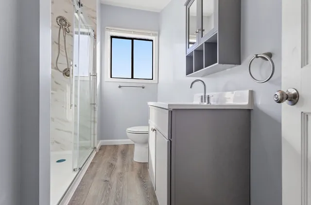 a bathroom with a sink a toilet and shower