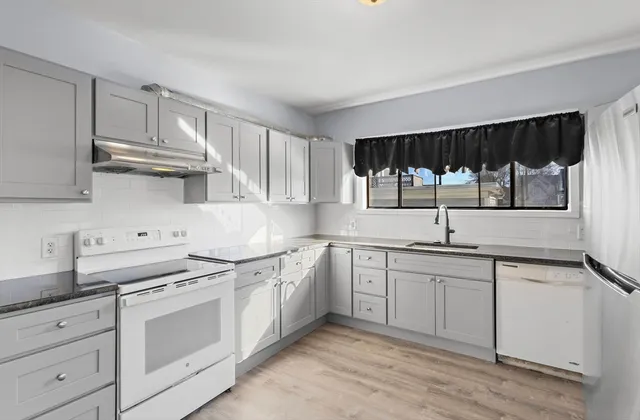a kitchen with stainless steel appliances a sink stove and cabinets