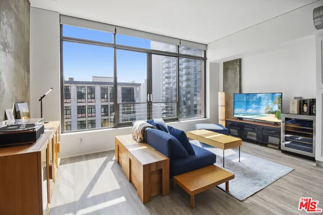 a living room with furniture a rug and a floor to ceiling window
