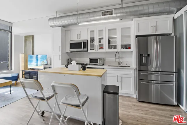 a kitchen with stainless steel appliances a refrigerator stove microwave and cabinets