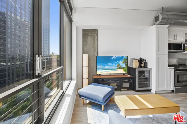 a living room with furniture a rug and kitchen view